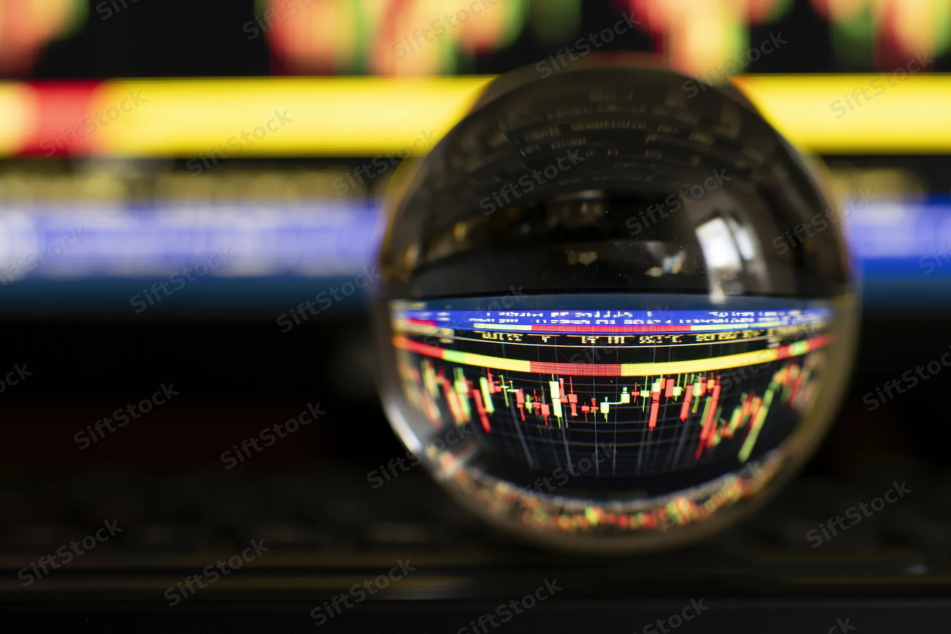 Crystal ball reflecting inverted stock market chart on a dark surface