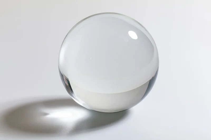 Clear glass sphere resting on a white surface in a studio setting