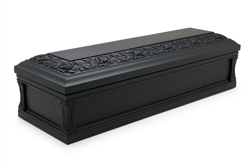 Black lacquered wooden coffin with carved floral relief on white background