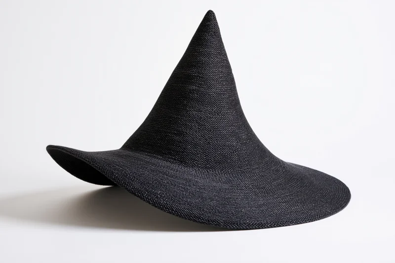 Dark charcoal knitted witch hat with asymmetric brim on white background