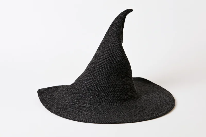 Black knitted witch hat with pointed asymmetric top on white background