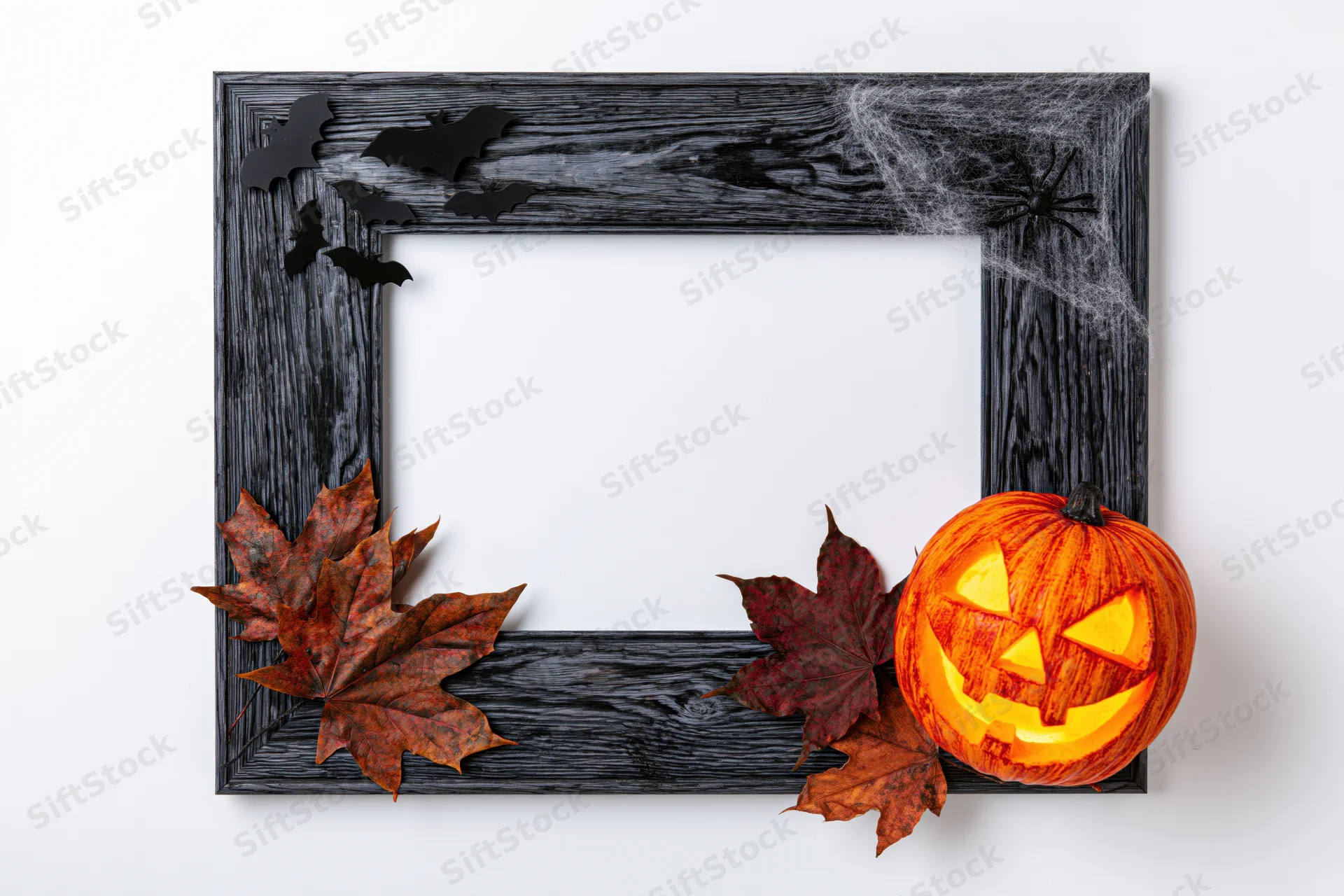 Dark weathered wooden frame decorated with halloween pumpkins, bats, spiderwebs, and autumn leaves, flat lay on white background