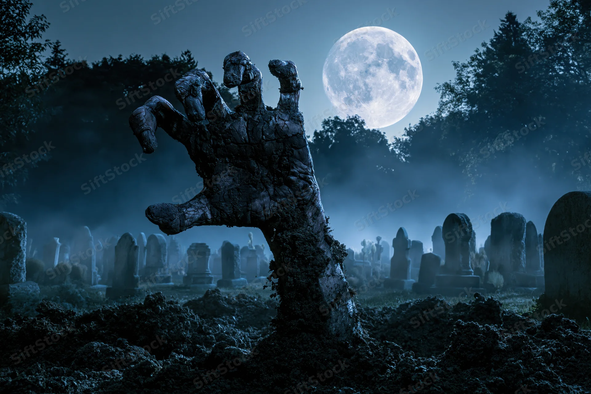 Decayed hand clawing from soil in a foggy graveyard under a full moon