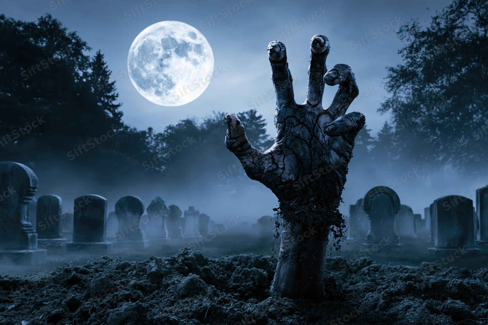 Decayed hand clawing from soil in a foggy graveyard under a full moon