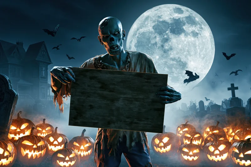 Decayed zombie holding blank wooden sign in graveyard surrounded by glowing pumpkins under full moon