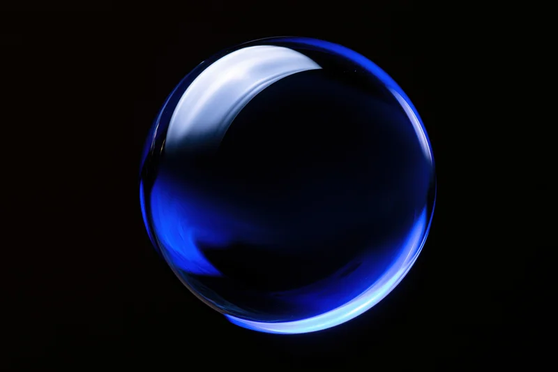 Deep blue glass sphere floating centered against pure black background