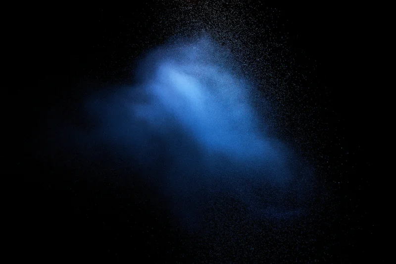 Blue powder cloud suspended in dark space