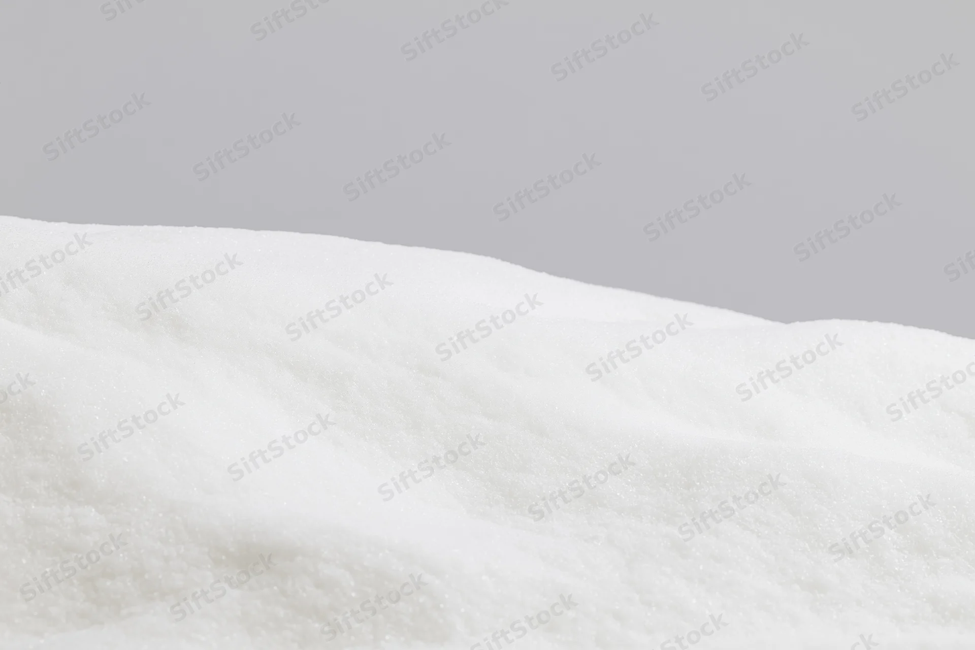 Low mound of fresh white snow filling the bottom third of the frame against a gray sky