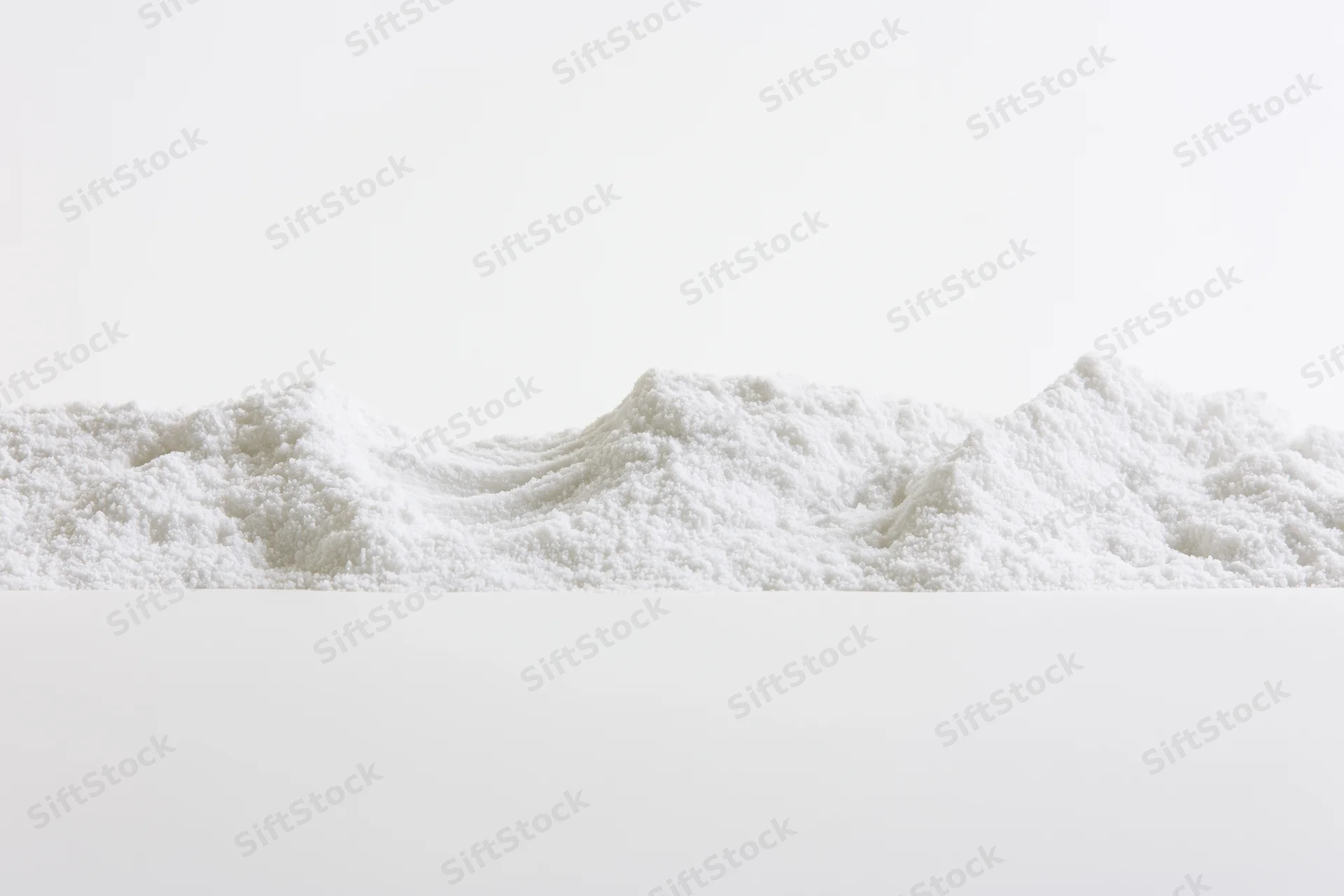 Fine white granular powder piled in a low ridge on a plain surface
