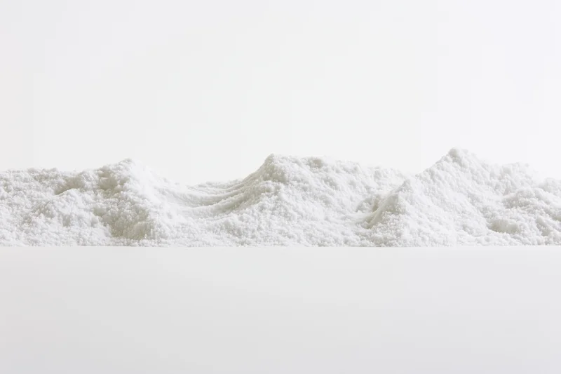 Fine white granular powder piled in a low ridge on a plain surface