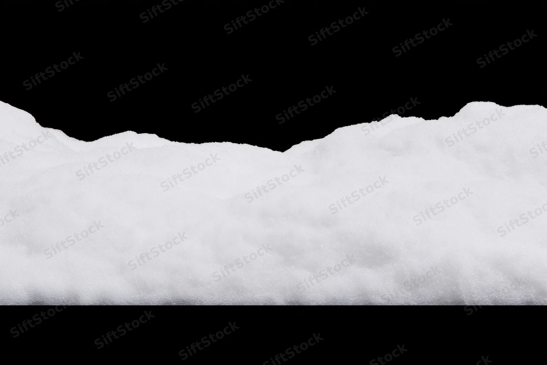 Low ridge of fresh white snow filling the bottom third of the frame against black background
