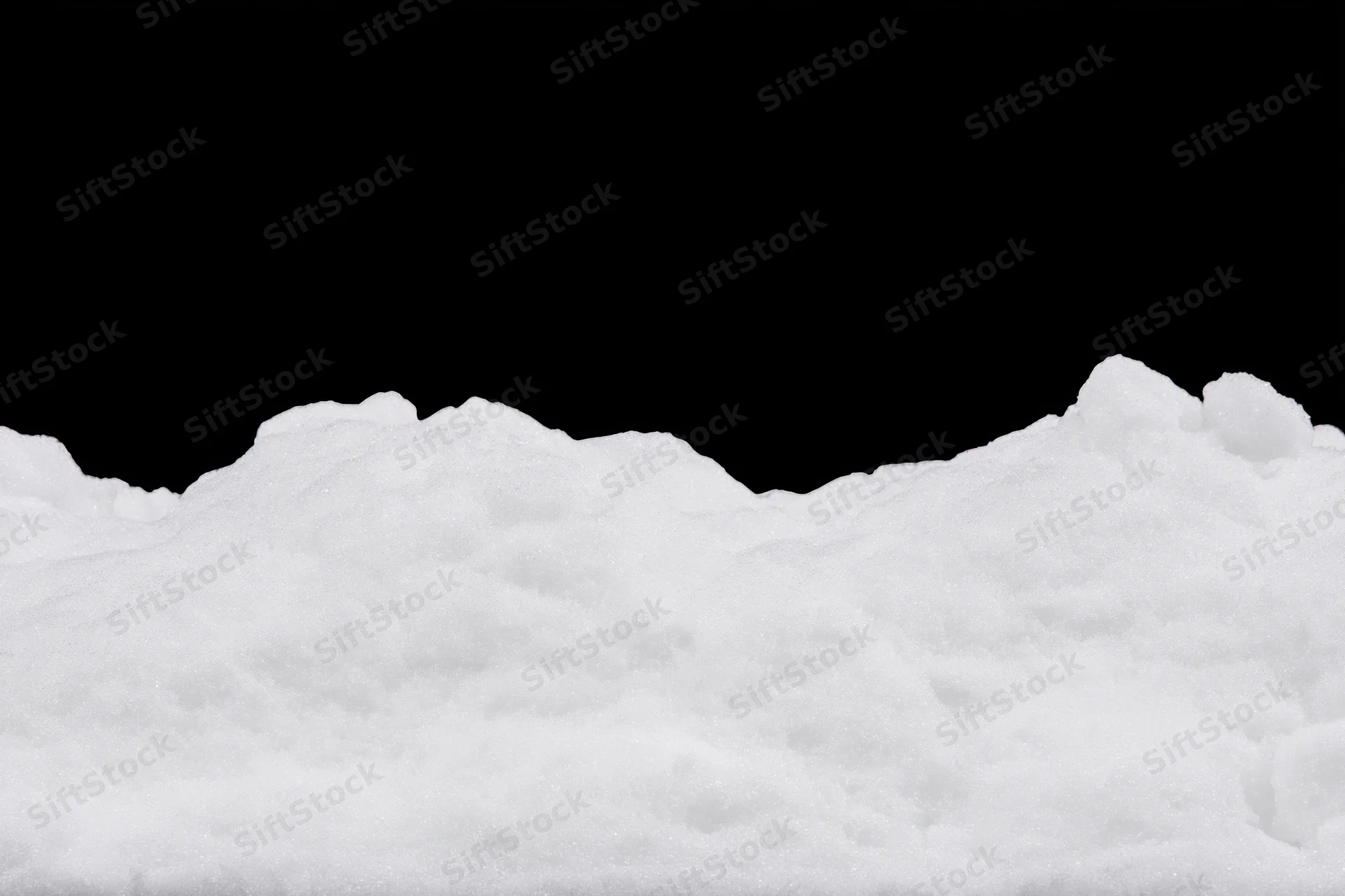 Low ridge of fresh white snow filling bottom third of frame against black background