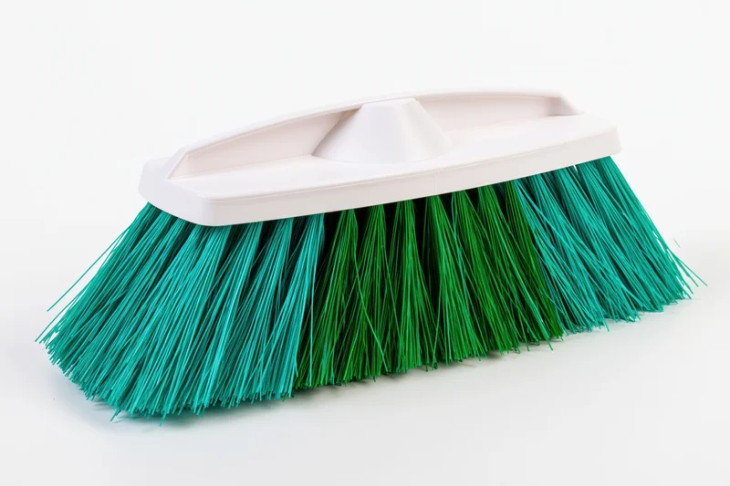 Plastic broom head with teal and green synthetic bristles on white background