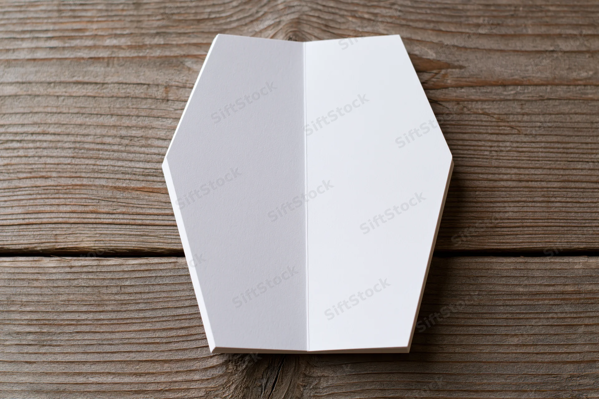 Open coffin-shaped blank white notepad on wooden surface