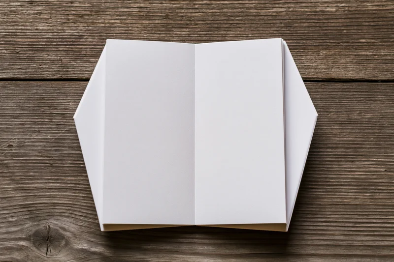 Open blank white coffin-shaped notepad on rustic wooden surface
