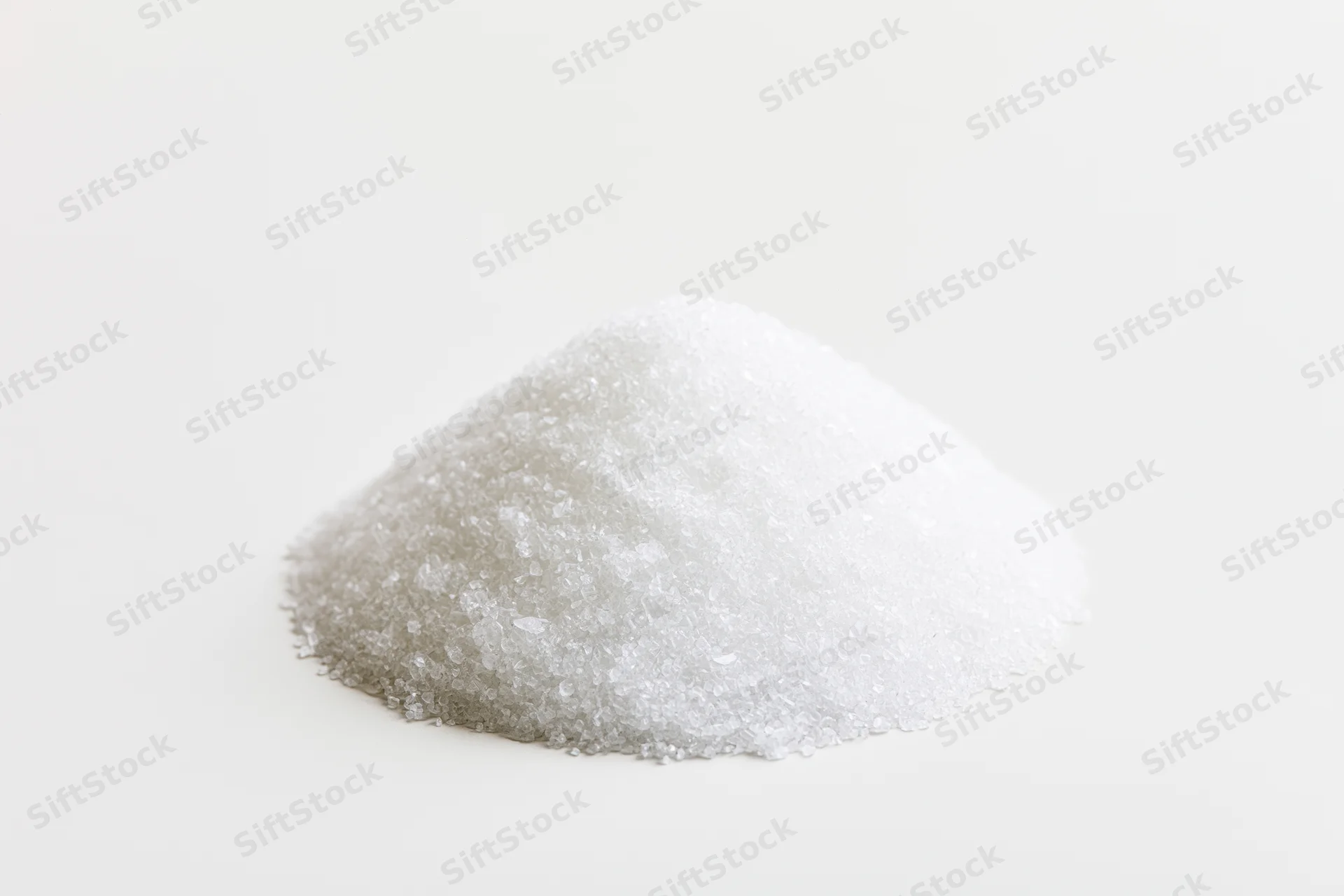 A heap of coarse white salt on a plain white surface