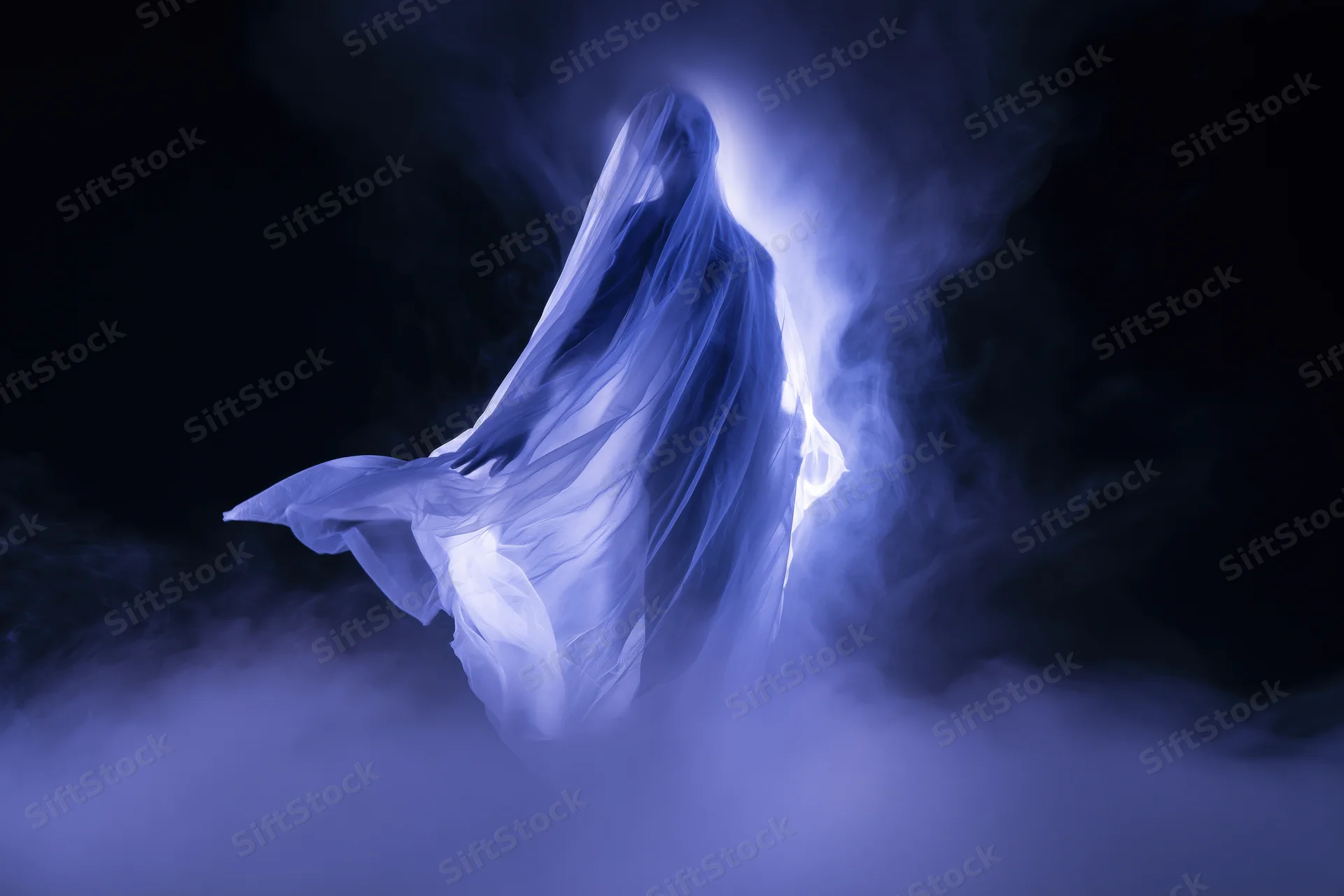 Ghostly figure floating in billowing sheer fabric amid blue smoke and light