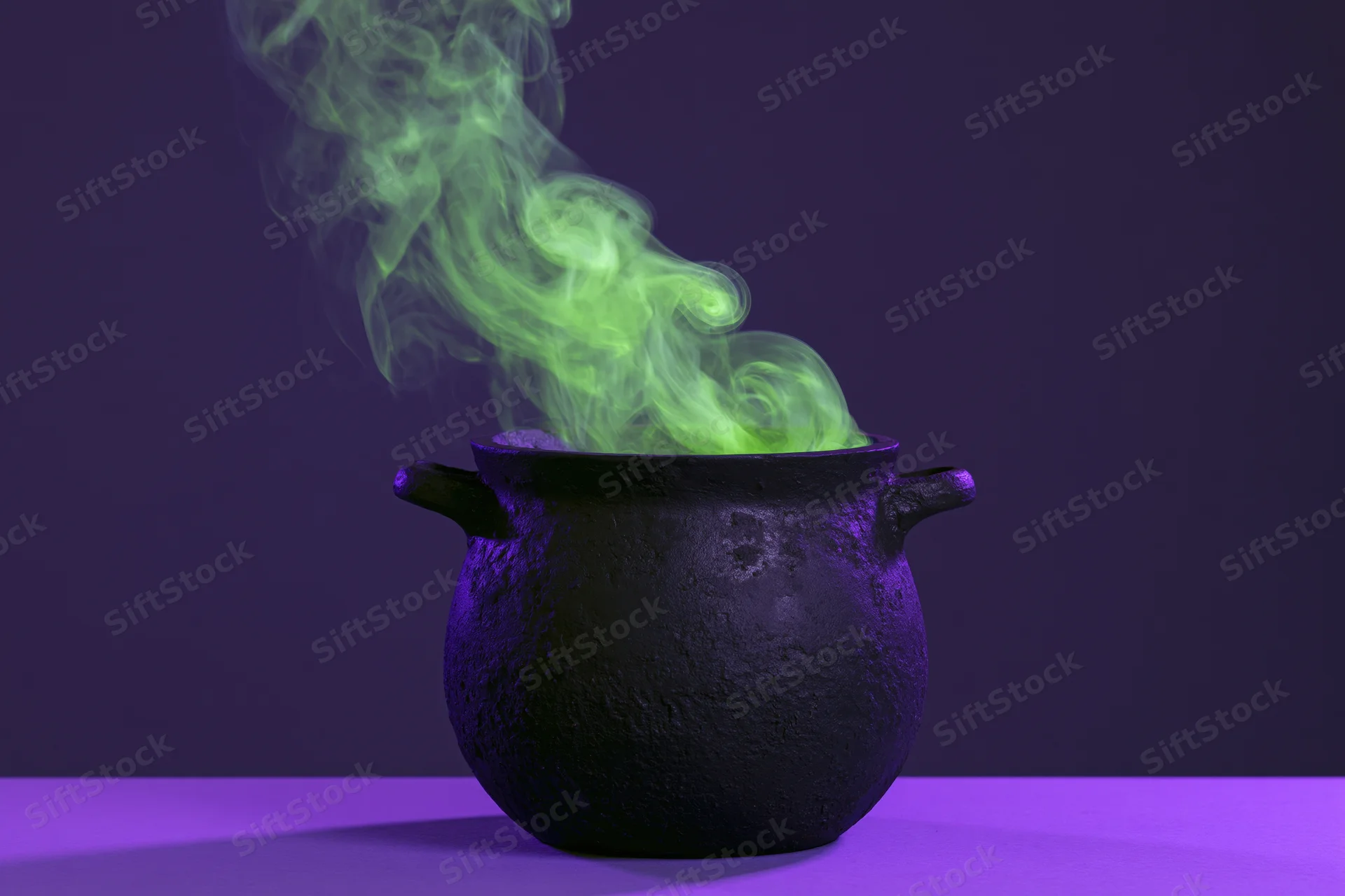Black cauldron emitting green smoke on purple surface