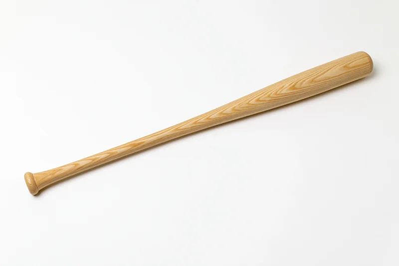 Wooden baseball bat lying diagonally on white surface