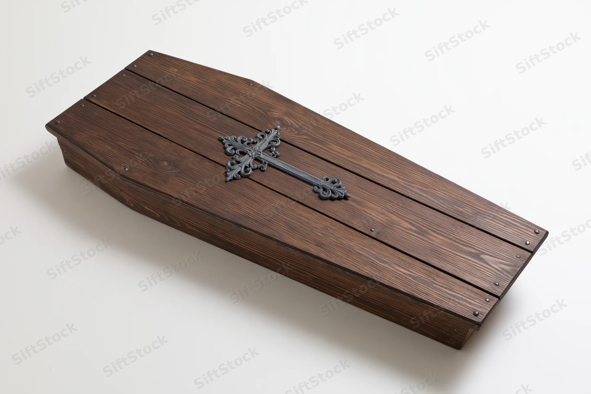 Wooden coffin lid with ornate metal cross on white background