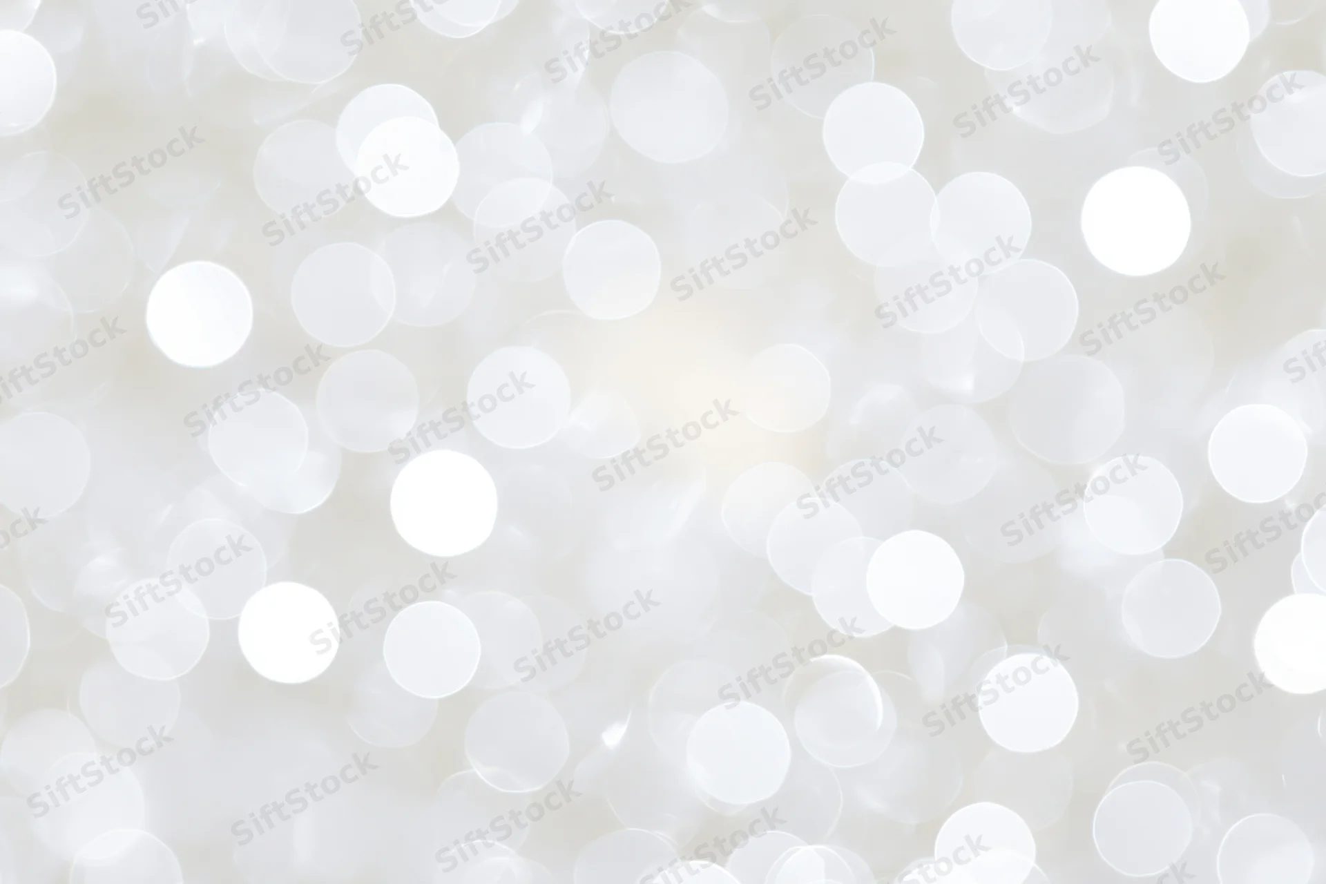 Abstract white bokeh background with soft glowing circles and bright highlights
