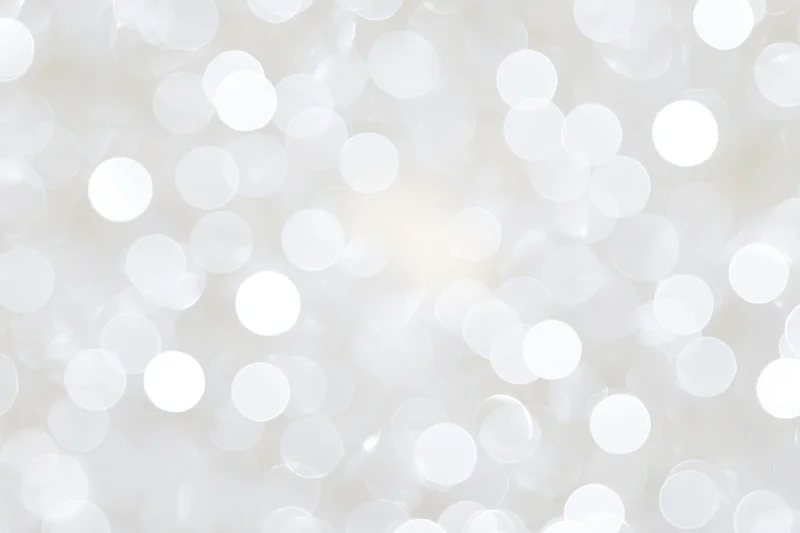 Abstract white bokeh background with soft glowing circles and bright highlights