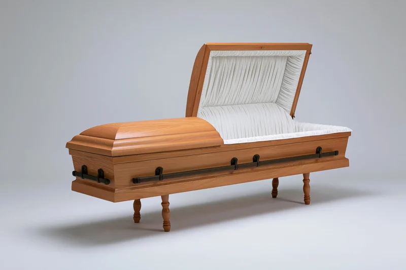Open wooden coffin with propped lid and white interior lining on gray studio background
