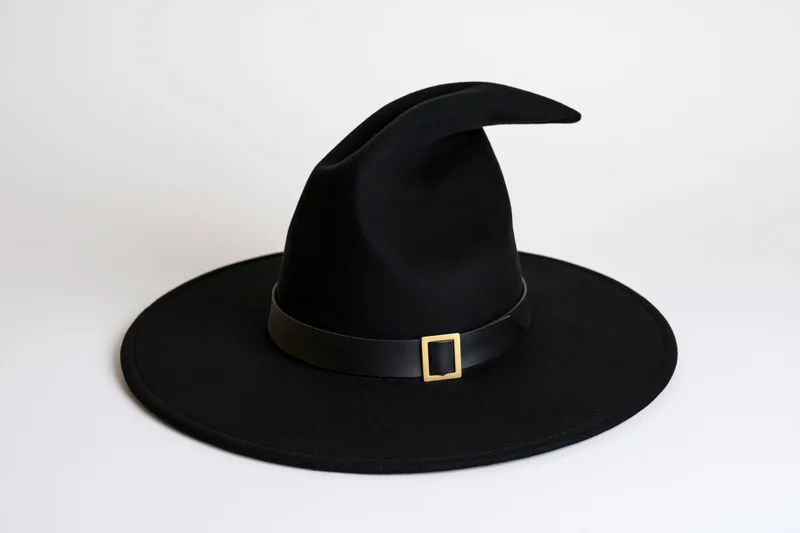 Black felt witch hat with curved tip and wide brim on white background