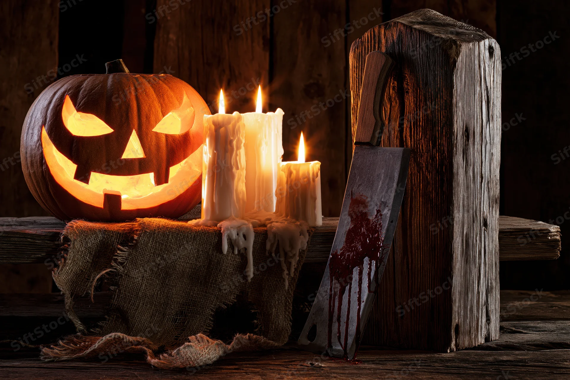 Carved jack-o-lantern glowing beside lit candles and a bloodied knife on a rustic wooden table