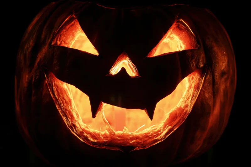 Carved pumpkin with glowing face lit from within at night