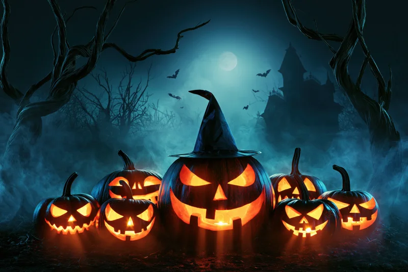 Carved jack-o-lanterns with glowing orange faces arranged on forest ground at night under moonlight with bats and castle in background