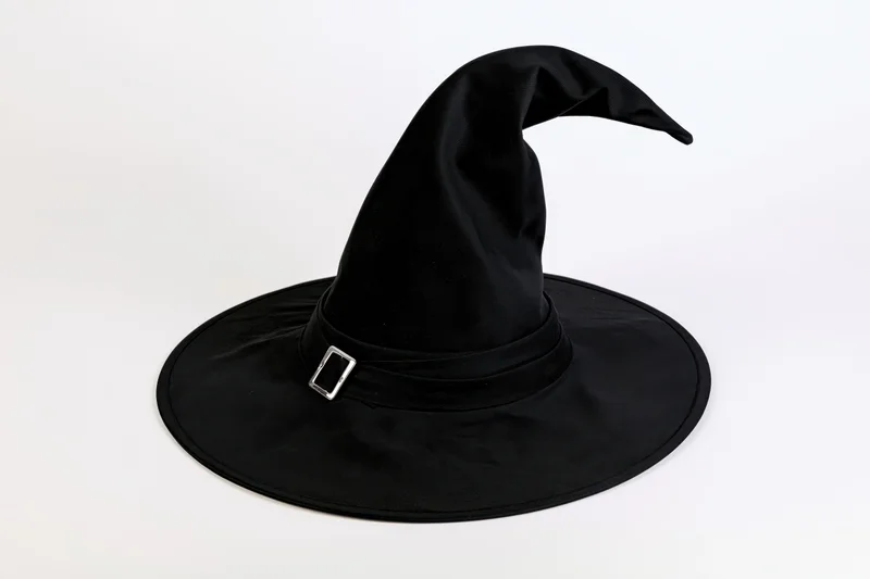 Black witch hat with tall pointed crown and wide brim on white background
