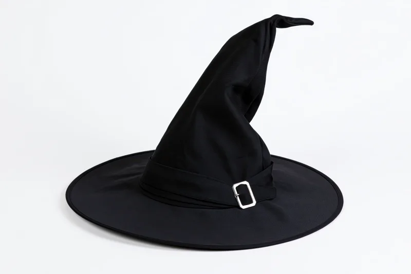 Black witch hat with tall pointed crown and wide brim on white background