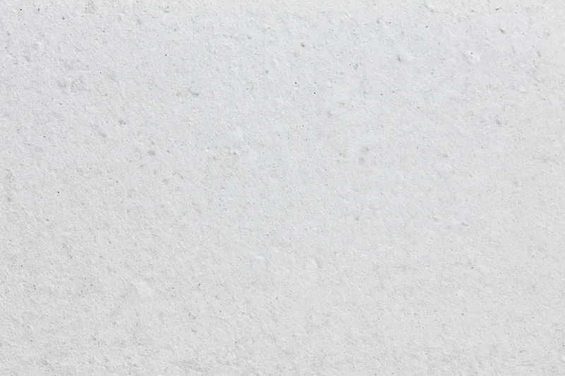 Close-up of white concrete surface with rough texture filling the frame
