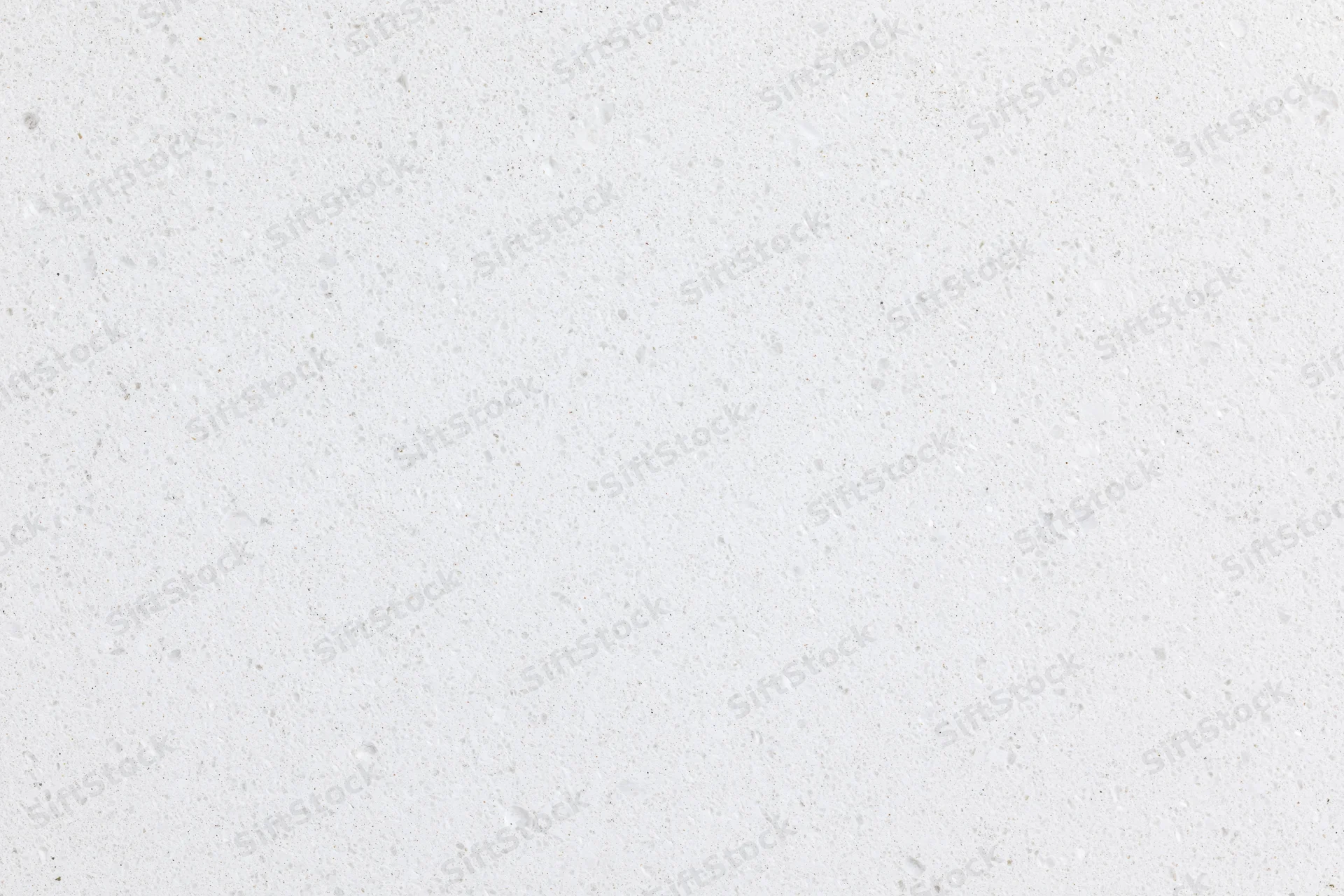 Close-up of a white concrete surface with speckled texture filling the frame