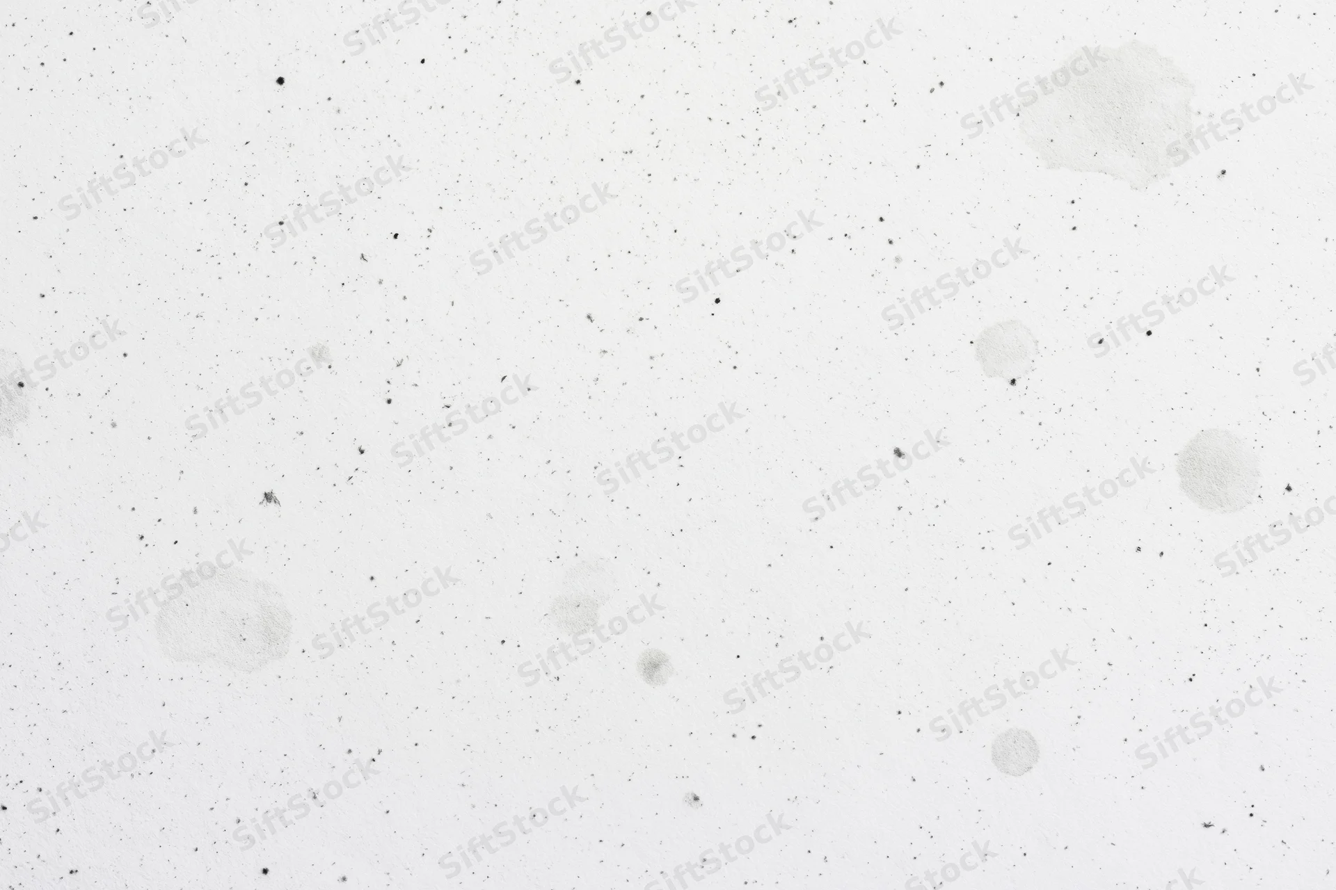 Close-up of white paper surface with speckles and stains, flat lay view