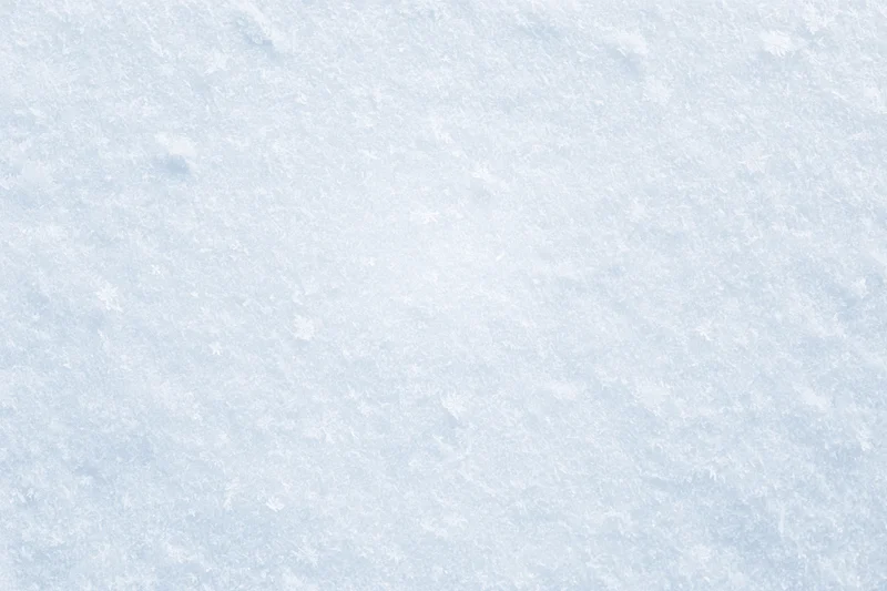 Close-up of fresh snow surface with scattered snowflakes in winter