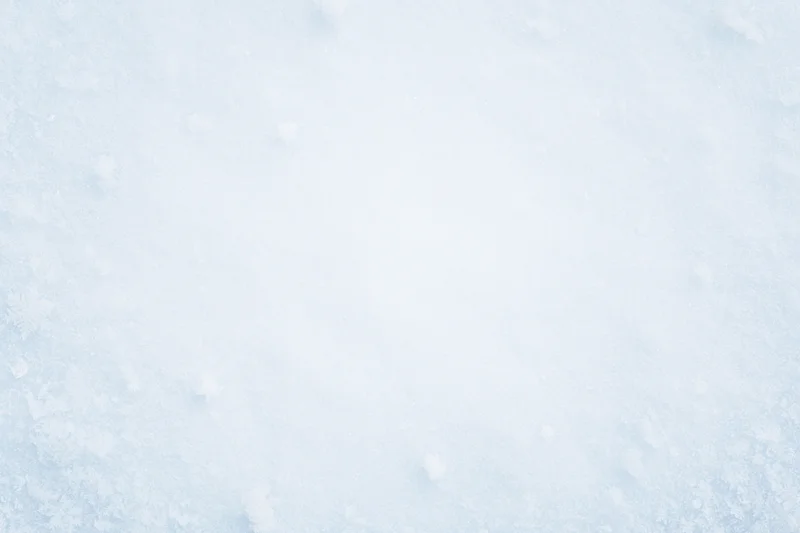 Close-up flat lay of fresh snow surface with scattered snowflakes
