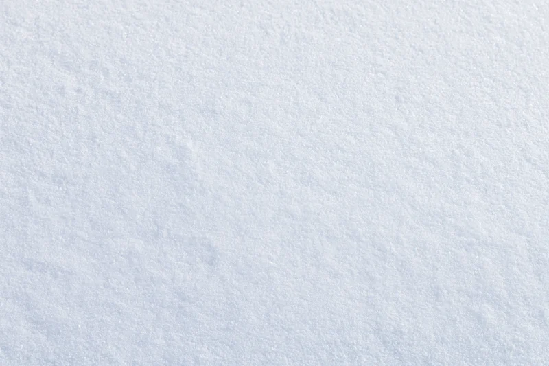 Close-up flat lay of undisturbed fresh snow surface filling the frame