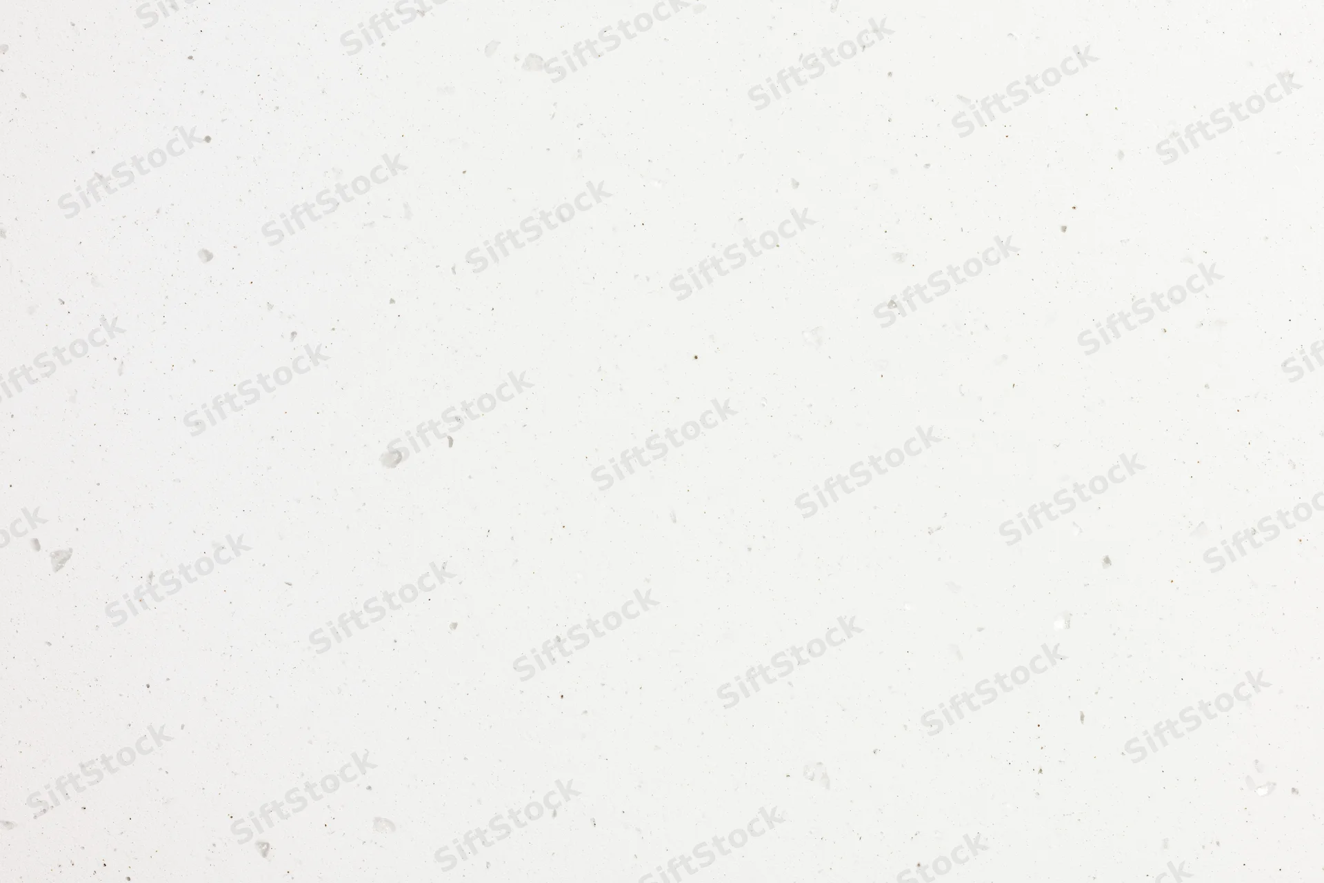 Close-up flat lay of white speckled paper or quartz surface texture