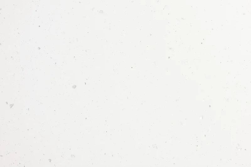 Close-up flat lay of white speckled paper or quartz surface texture