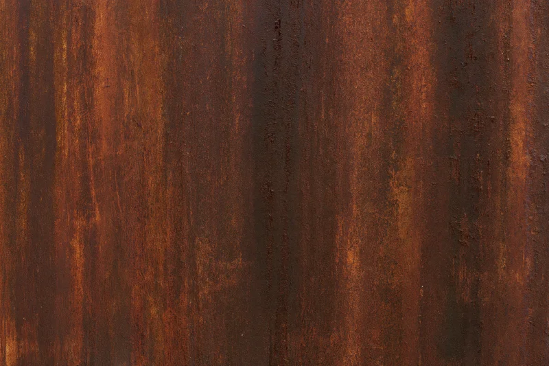 Close-up of heavily rusted metal surface with vertical striations and weathered texture