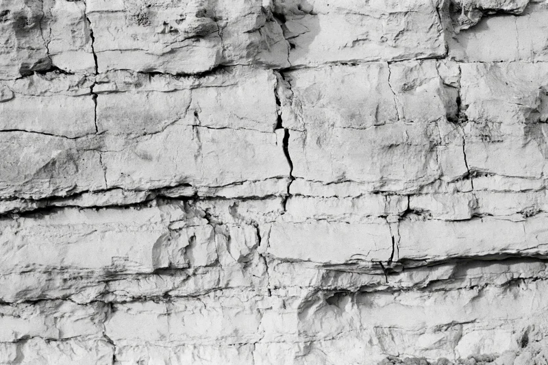 Close-up of layered sedimentary rock face showing natural fractures and strata