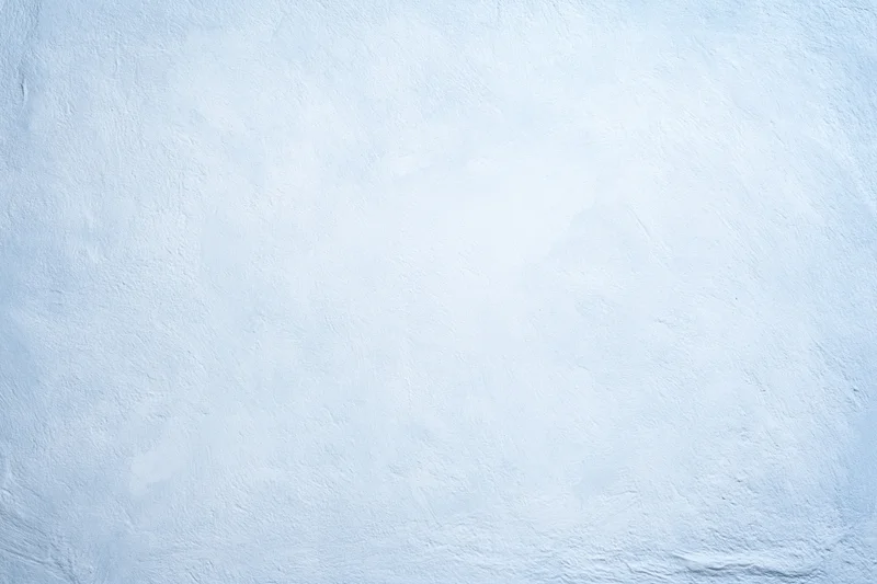 Close-up of a pale blue-white painted concrete wall with textured surface