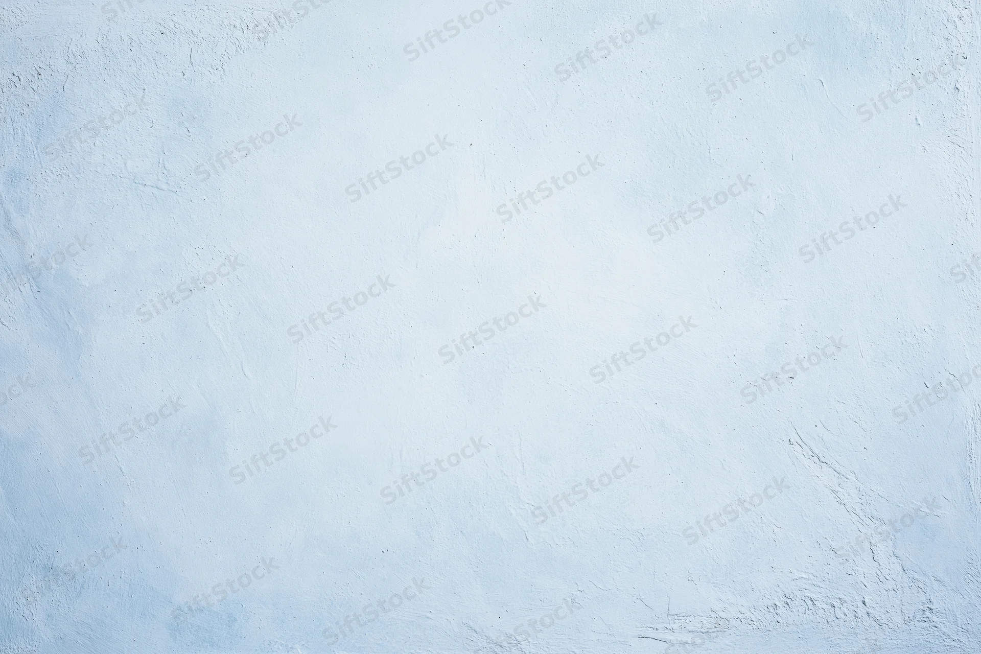 Close-up of a pale blue-white painted concrete wall with textured surface