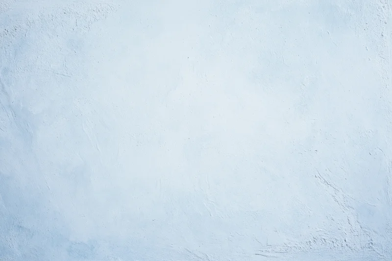 Close-up of a pale blue-white painted concrete wall with textured surface
