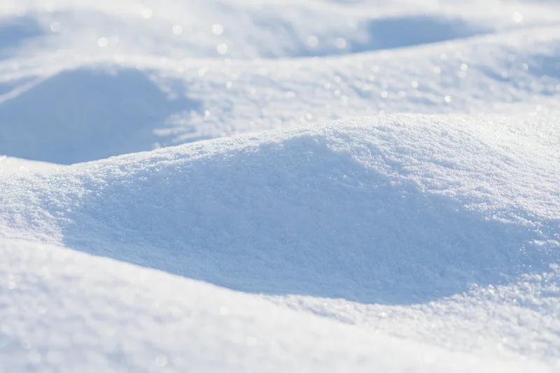 Closeup of wind-sculpted snow drift at ground level in winter landscape