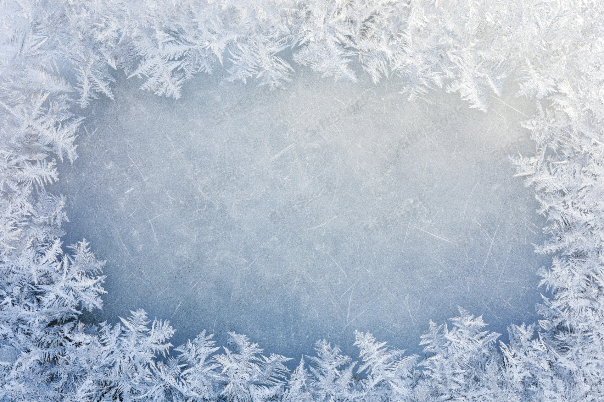 Frosted window pane with ice crystals forming a frame around a clear center