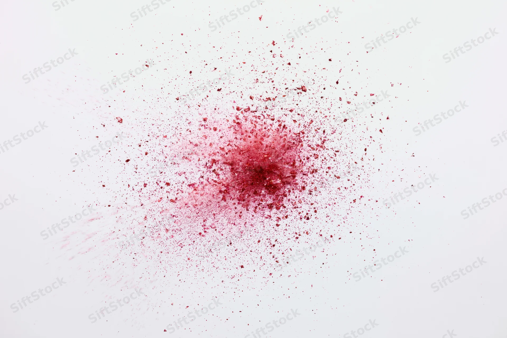 Red powder burst in mid-air against white background