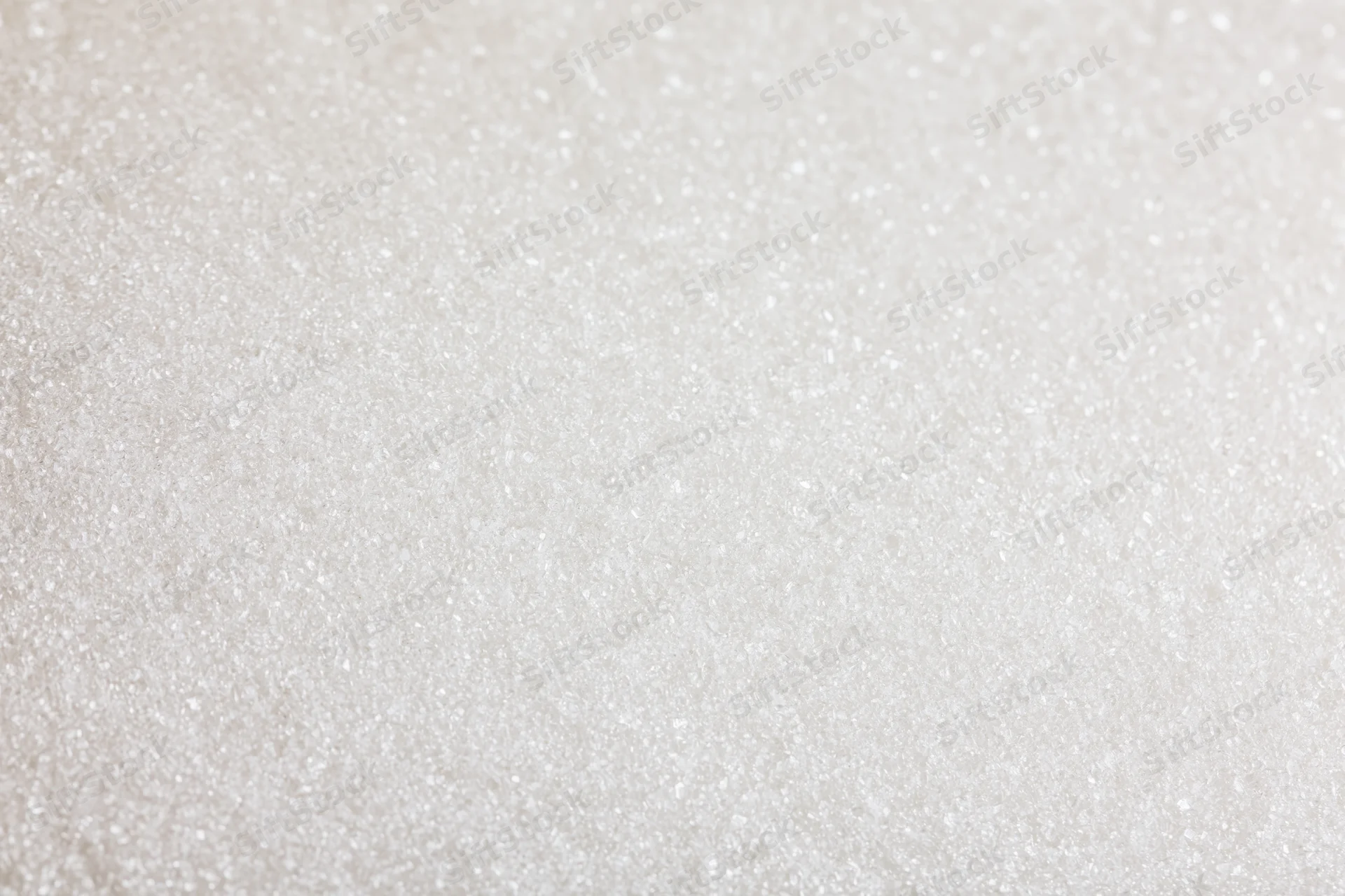 Close-up of granulated white sugar filling the frame with sparkling texture